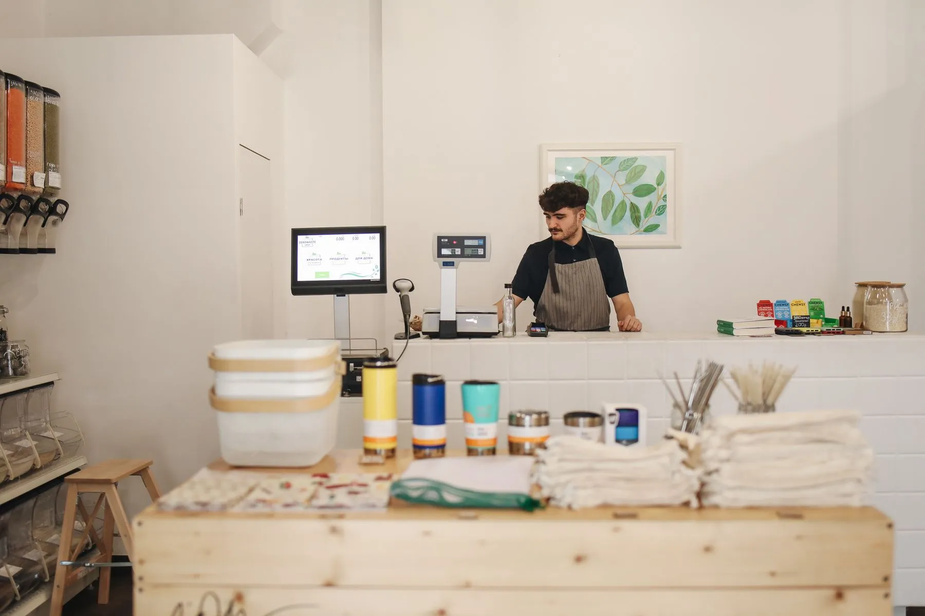 A young store owner at the counter of his small shop